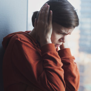 traumatized person covering her ears